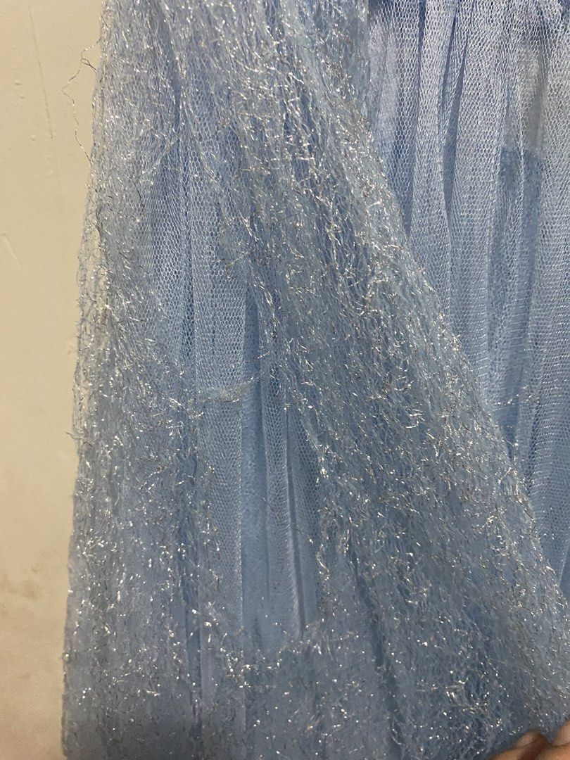 Elsa Inspired Dress (Category: Babies & Kids Fashion) located in Las Pinas. Submitted by dhyn29 (Listing ID 1466677279, Image 3). Description: - Light blue princess costume dress with blue velvet-like upper body - Off-the-shoulder draped sleeves and white lace bodice panel - Large silver gem brooch attached at the neckline - Sparkly silver textured tulle overlay on the skirt - Condition note: One strap has a torn seam near the arm opening which r