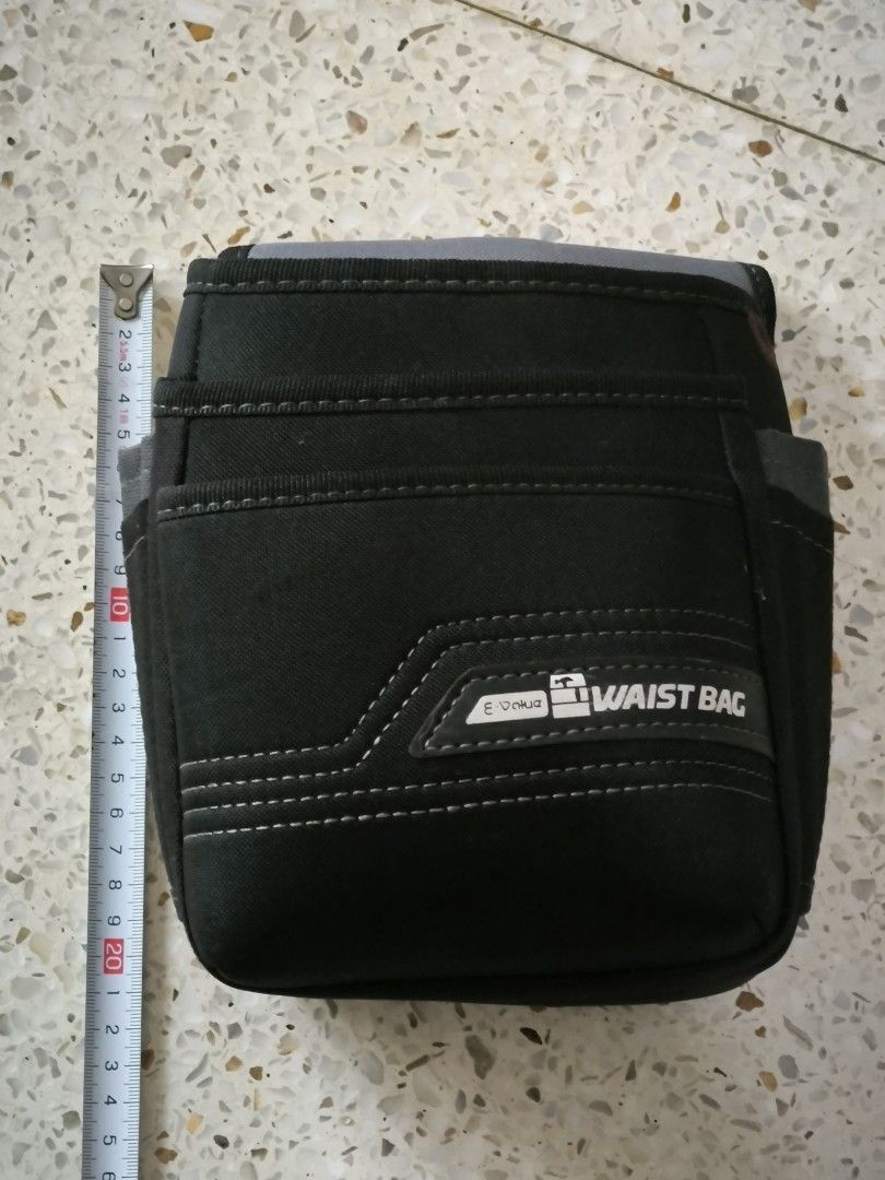 E-Value Tool Waist Bag Utility Pouch (Category: Belt bags, Clutches and Pouches) located in Angeles City. Submitted by yellowbrickstore (Listing ID 1466639388, Image 1). Description: - Brand: E-Value - Color: Heavy-duty black fabric with stylish grey trim and contrast stitching - Storage: Multiple front pouches and side slots for organized tool storage - Durability: Sturdy belt loop back reinforced with metal rivets - Condition: Clean interior co