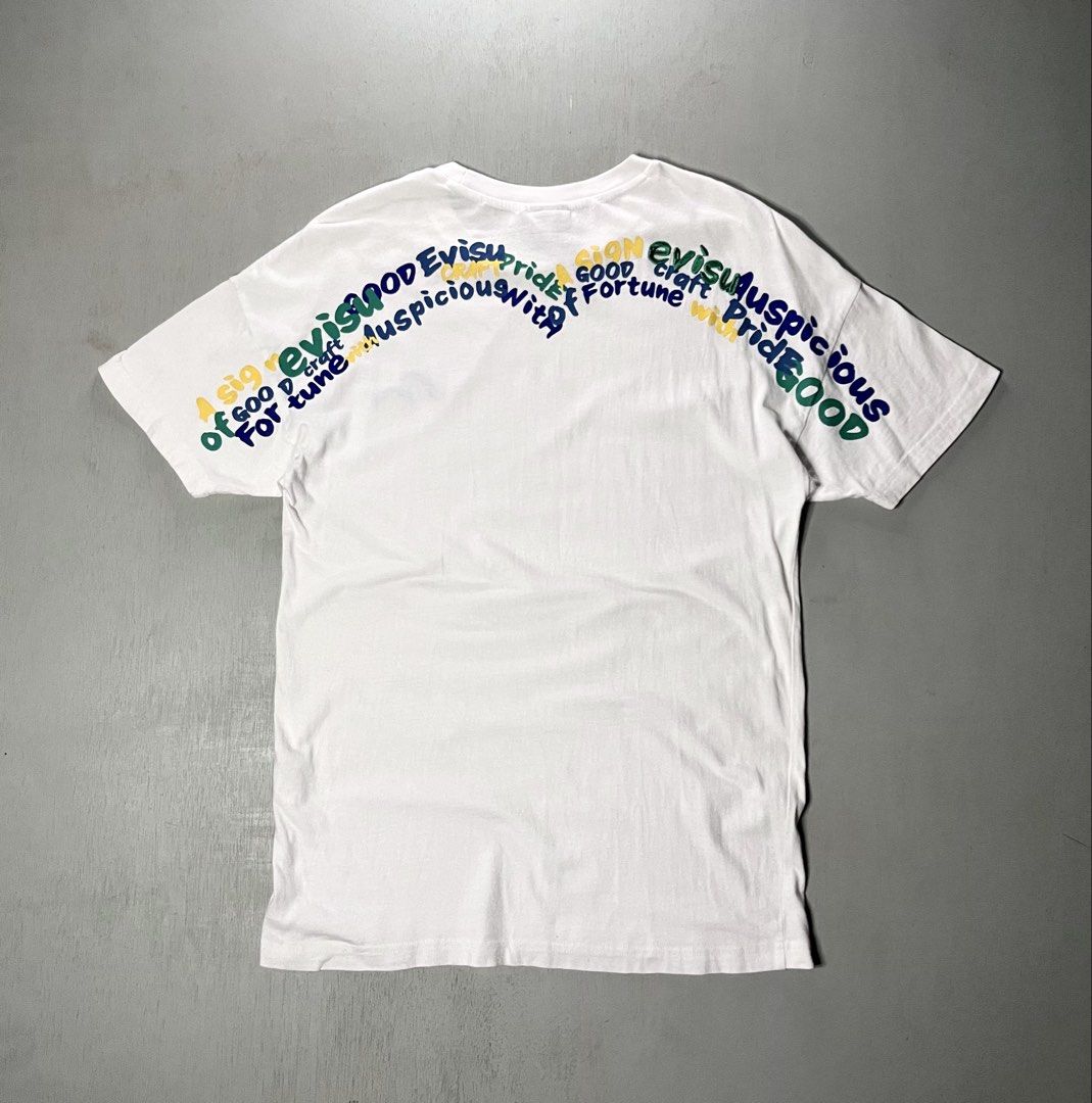 Evisu White Graphic T-Shirt (Category: Tshirts & Polo Shirts ) located in Catbalogan. Submitted by yellfindss (Listing ID 1466745457, Image 1). Description: - Brand: Evisu -18/27 - Color: White - Style: Short sleeve crew neck tee - Details: Embroidered blue seagull logo on left chest - Back Design: Multicolored printed typography across the shoulders - Interior: Branded taping inside the collar - Condition: Clean overall.