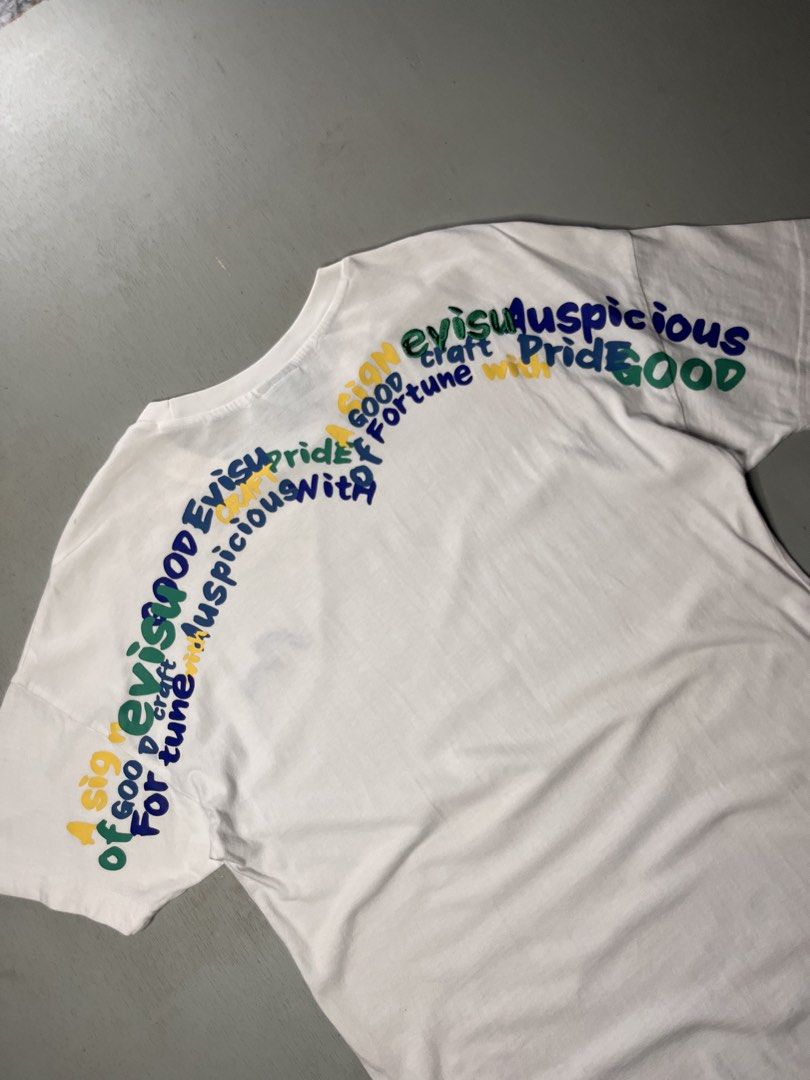 Evisu White Graphic T-Shirt (Category: Tshirts & Polo Shirts ) located in Catbalogan. Submitted by yellfindss (Listing ID 1466745457, Image 2). Description: - Brand: Evisu -18/27 - Color: White - Style: Short sleeve crew neck tee - Details: Embroidered blue seagull logo on left chest - Back Design: Multicolored printed typography across the shoulders - Interior: Branded taping inside the collar - Condition: Clean overall.