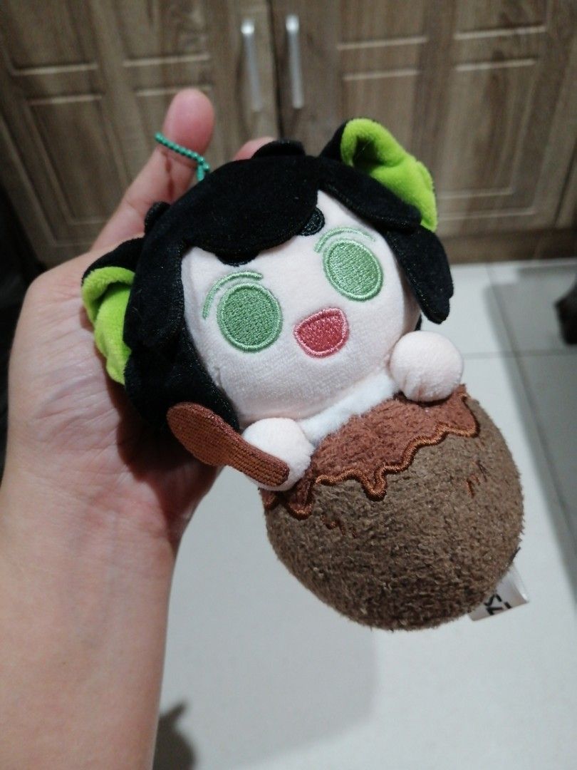 FANSZ Character Plush Keychain (Category: Plushies & Soft Toys) located in Angono. Submitted by rlinee_93 (Listing ID 1466697998, Image 1). Description: - Brand: Authentic FANSZ plush character keychain - Design: Black hair, striking green eyes, and holding a tiny spoon - Details: Brown round base with realistic stitching and signature FANSZ tag - Attachment: Includes a durable green ball chain for easy hanging - Condition: Brand new, perfect for