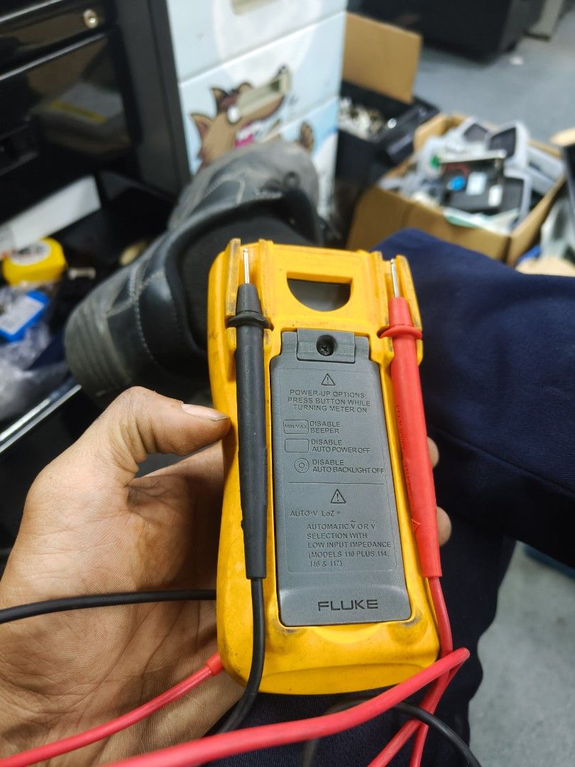 Fluke 115 True RMS Multimeter (Category: Construction Tools & Equipment) located in Taguig. Submitted by martin1990easy (Listing ID 1466703287, Image 2). Description: - Model: Fluke 115 Digital Multimeter - Condition: Used with minor workspace scuffs and dust; fully functional - Included Accessories: Original yellow protective rubber holster, black test lead, and red test lead - Features: Standard center rotary dial, top digital screen, Hold, Min