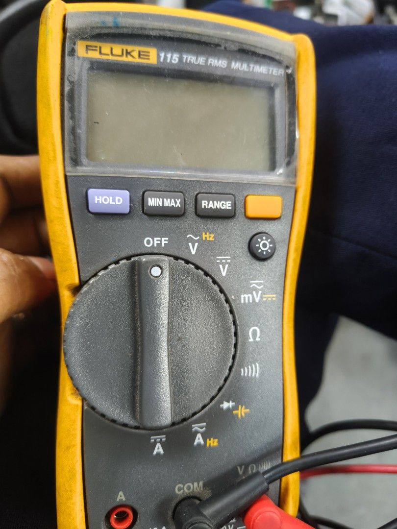 Fluke 115 True RMS Multimeter (Category: Construction Tools & Equipment) located in Taguig. Submitted by martin1990easy (Listing ID 1466703287, Image 1). Description: - Model: Fluke 115 Digital Multimeter - Condition: Used with minor workspace scuffs and dust; fully functional - Included Accessories: Original yellow protective rubber holster, black test lead, and red test lead - Features: Standard center rotary dial, top digital screen, Hold, Min