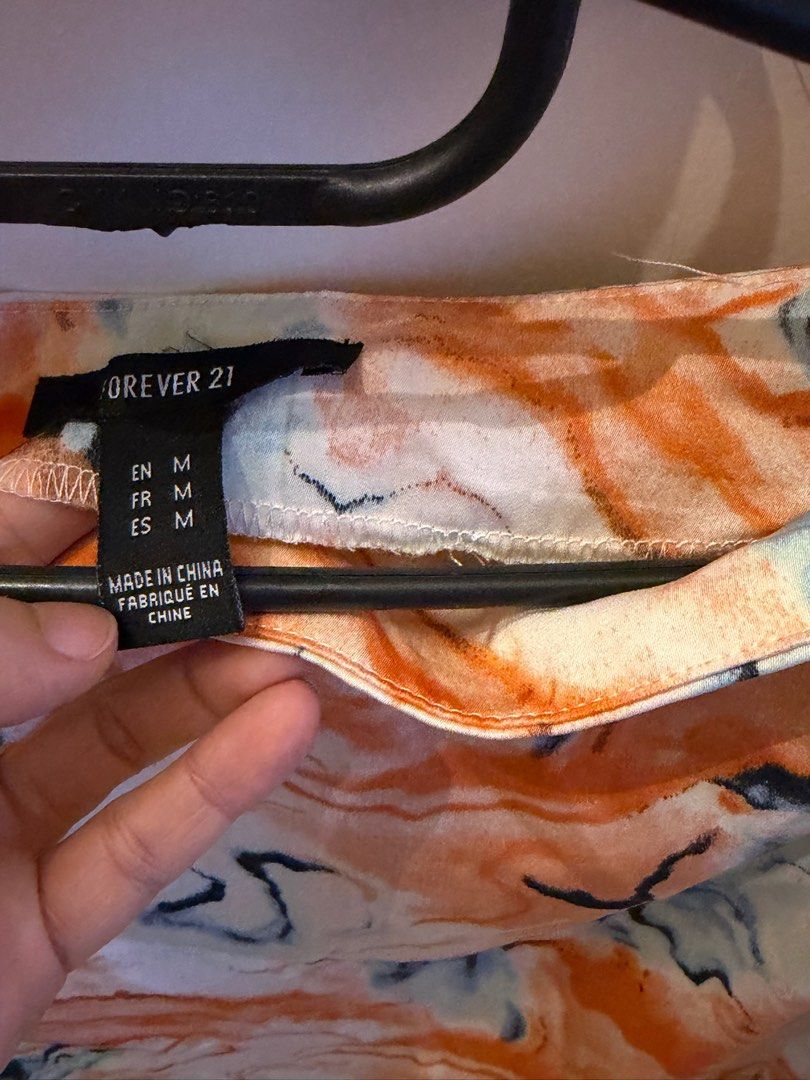 Forever 21 Orange Marble Two-Piece Set (Category: Sets or Coordinates) located in Quezon City. Submitted by bubspreloved (Listing ID 1466720007, Image 3). Description: - Brand: Forever 21 - Item: Two-piece set (Collared button-up top with front tie + matching mini skirt) - Color/Pattern: Bright orange marble print - Size: Medium - Condition: Great pre-loved condition - Perfect for: Summer days, casual outings, and hangouts - Style tip: Wear toget