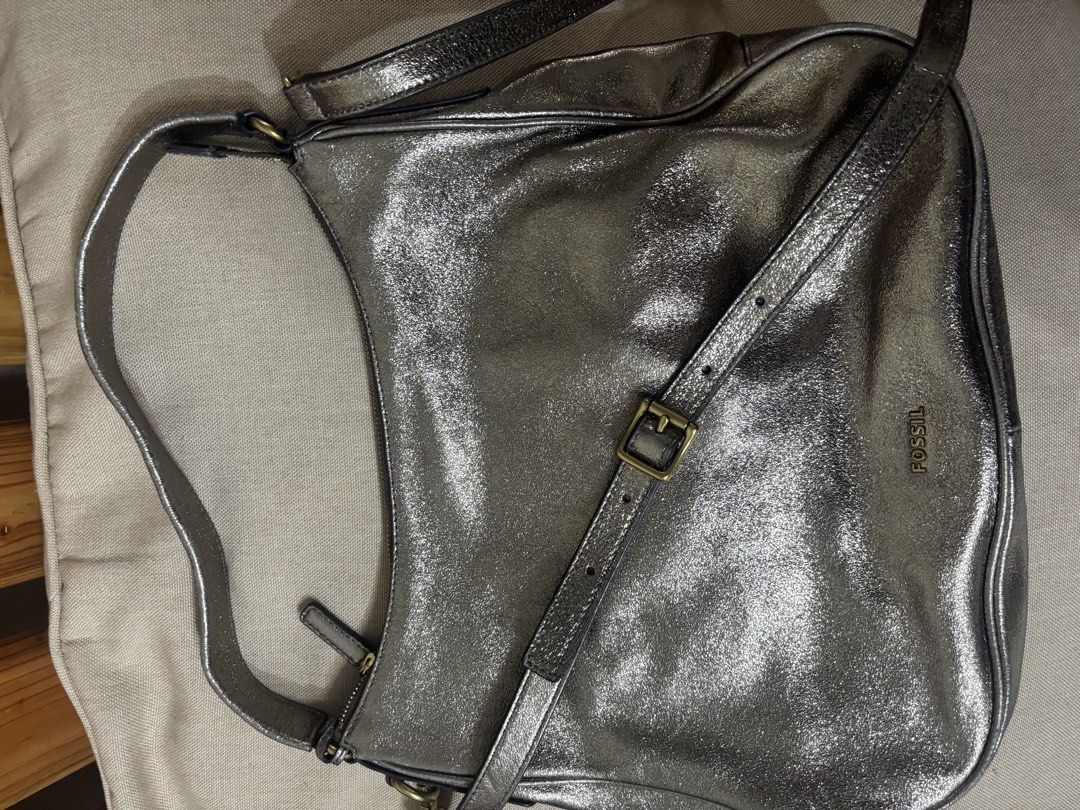 Fossil Metallic Bronze Leather Shoulder Bag (Category: Shoulder Bags) located in Famy. Submitted by frenchmacaroon (Listing ID 1466581498, Image 2). Description: - Brand: Fossil - Color: Metallic bronze with a subtle shiny finish - Material: Genuine leather with brass hardware - Closure: Secure zip-top closure - Features: Includes a detachable/adjustable long strap and signature Fossil key charm - Storage: Roomy interior, great size for daily ess