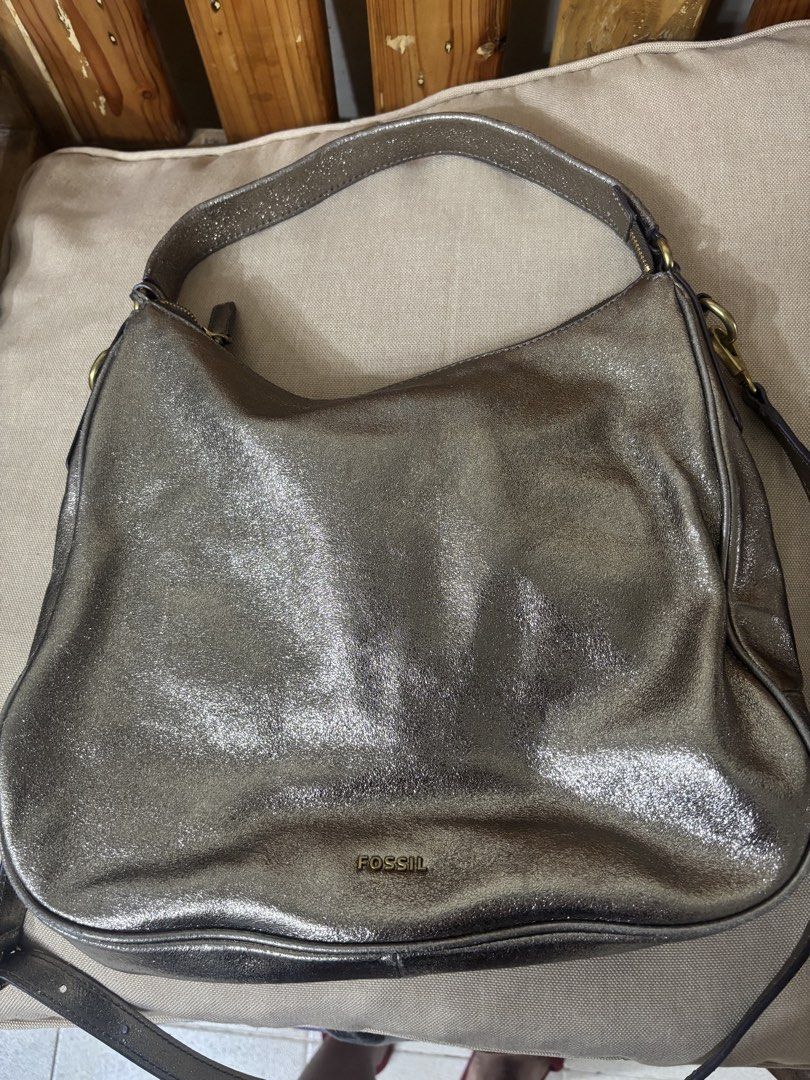 Fossil Metallic Bronze Leather Shoulder Bag (Category: Shoulder Bags) located in Famy. Submitted by frenchmacaroon (Listing ID 1466581498, Image 1). Description: - Brand: Fossil - Color: Metallic bronze with a subtle shiny finish - Material: Genuine leather with brass hardware - Closure: Secure zip-top closure - Features: Includes a detachable/adjustable long strap and signature Fossil key charm - Storage: Roomy interior, great size for daily ess