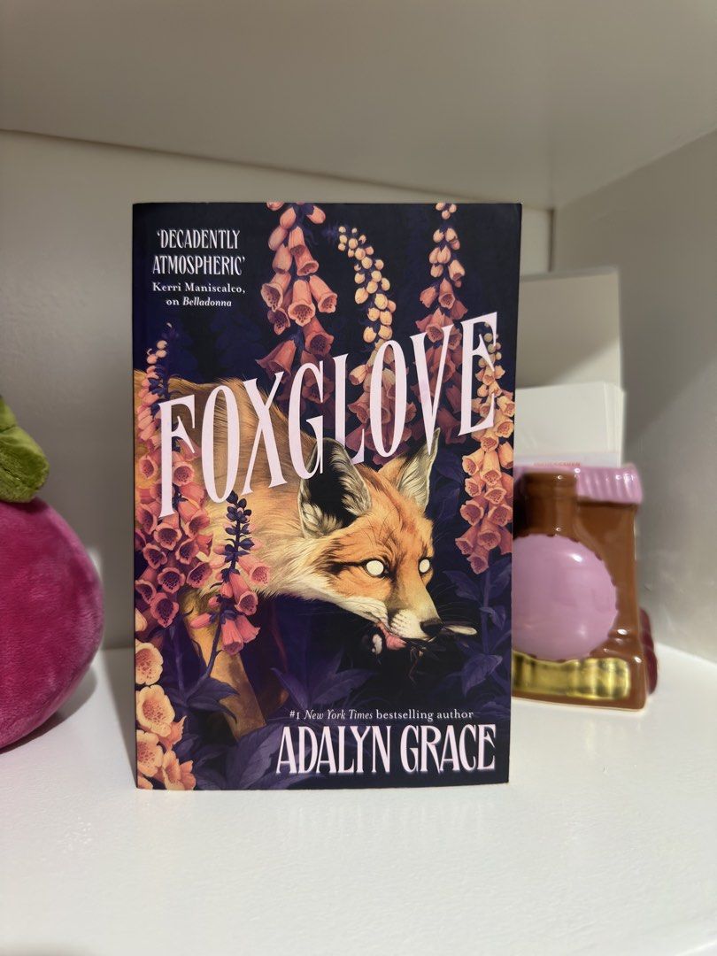 Foxglove by Adalyn Grace Novel (Category: Storybooks) located in Manila. Submitted by atlantis386 (Listing ID 1466719483, Image 1). Description: - Title: Foxglove by Adalyn Grace (#1 New York Times Bestselling Author) - Format: Paperback, clean and well-maintained condition - Cover Art: Stunning red fox design amid dark floral foliage - Special Feature: Includes a blurb from bestselling author Kerri Maniscalco on the front - Shipping options avai
