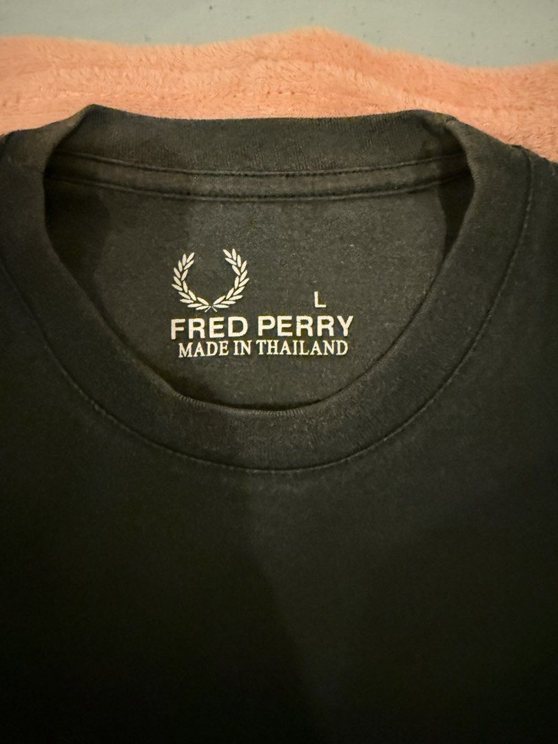 Fred Perry Black T-Shirt Size L (Category: Tshirts & Polo Shirts ) located in Pasig City. Submitted by shop.gelss (Listing ID 1466770318, Image 2). Description: - Brand: Fred Perry - Color: Black - Size: Large (Regular fit) - Design: Classic crew neck with embroidered laurel wreath logo on the chest - Origin: Made in Thailand - Material: Soft, comfortable fabric.