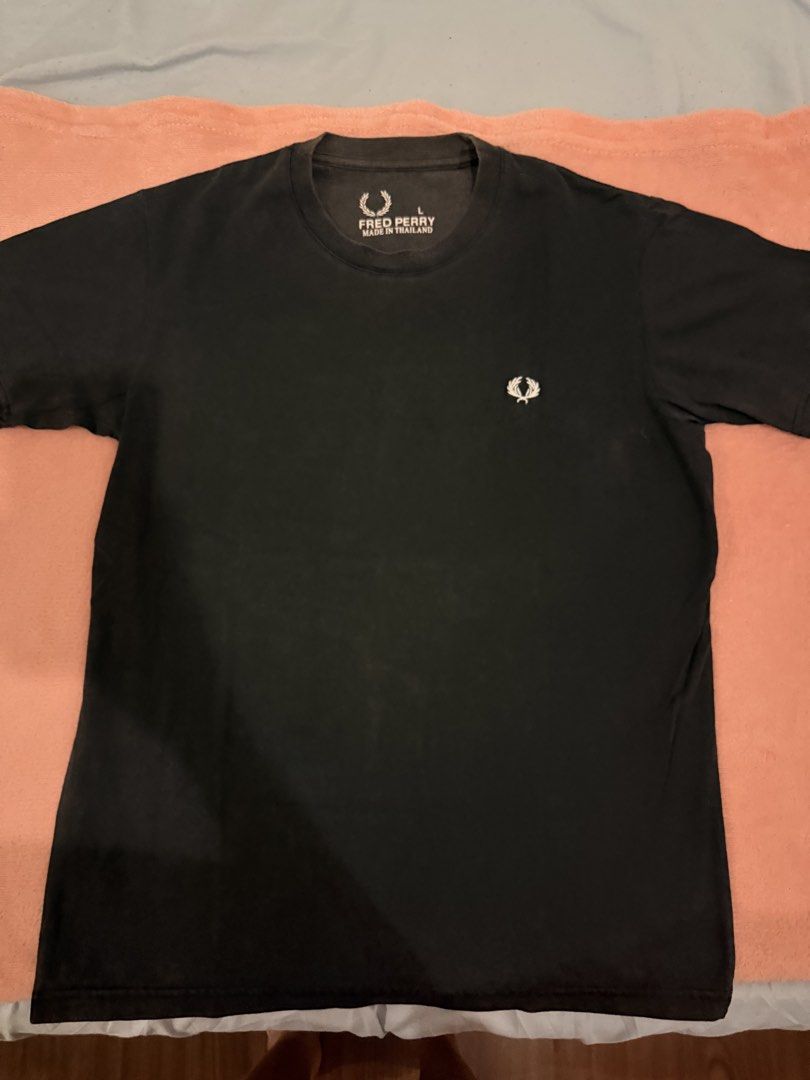 Fred Perry Black T-Shirt Size L (Category: Tshirts & Polo Shirts ) located in Pasig City. Submitted by shop.gelss (Listing ID 1466770318, Image 1). Description: - Brand: Fred Perry - Color: Black - Size: Large (Regular fit) - Design: Classic crew neck with embroidered laurel wreath logo on the chest - Origin: Made in Thailand - Material: Soft, comfortable fabric.