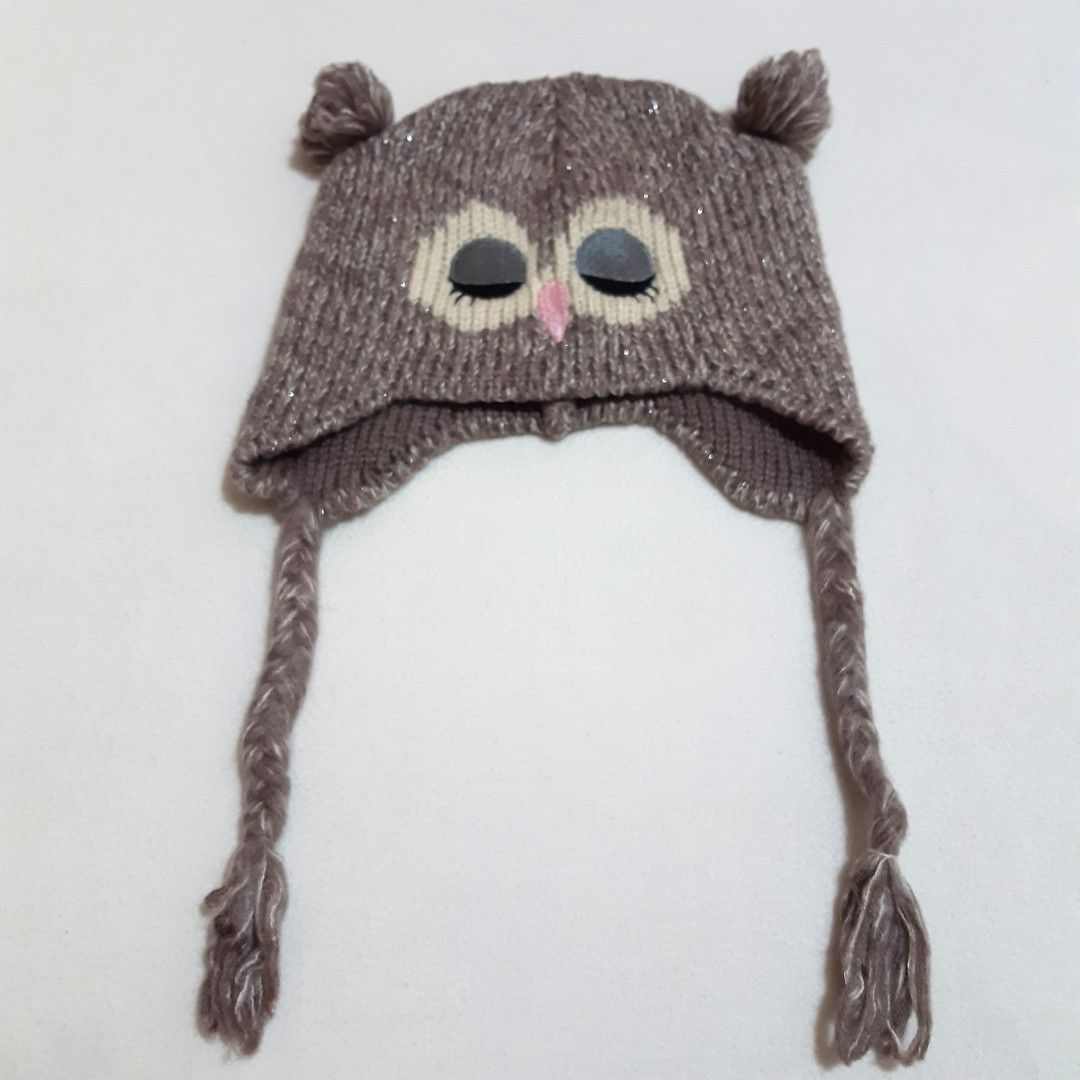 Funky Fish Owl Knitted Beanie Hat with Earflaps (Category: Hats & Beanies) located in Tuguegarao City. Submitted by thriftedtreasures101.1 (Listing ID 1466645526, Image 2). Description: Playful and quirky style beanie hat. It features a knitted eye patches with close eyelids, a tiny pink triangle beak, small ear-like tufts, braided earflap cords and a subtle metallic or glitter thread woven into the knit. Slightly used, in good condition. Size Me