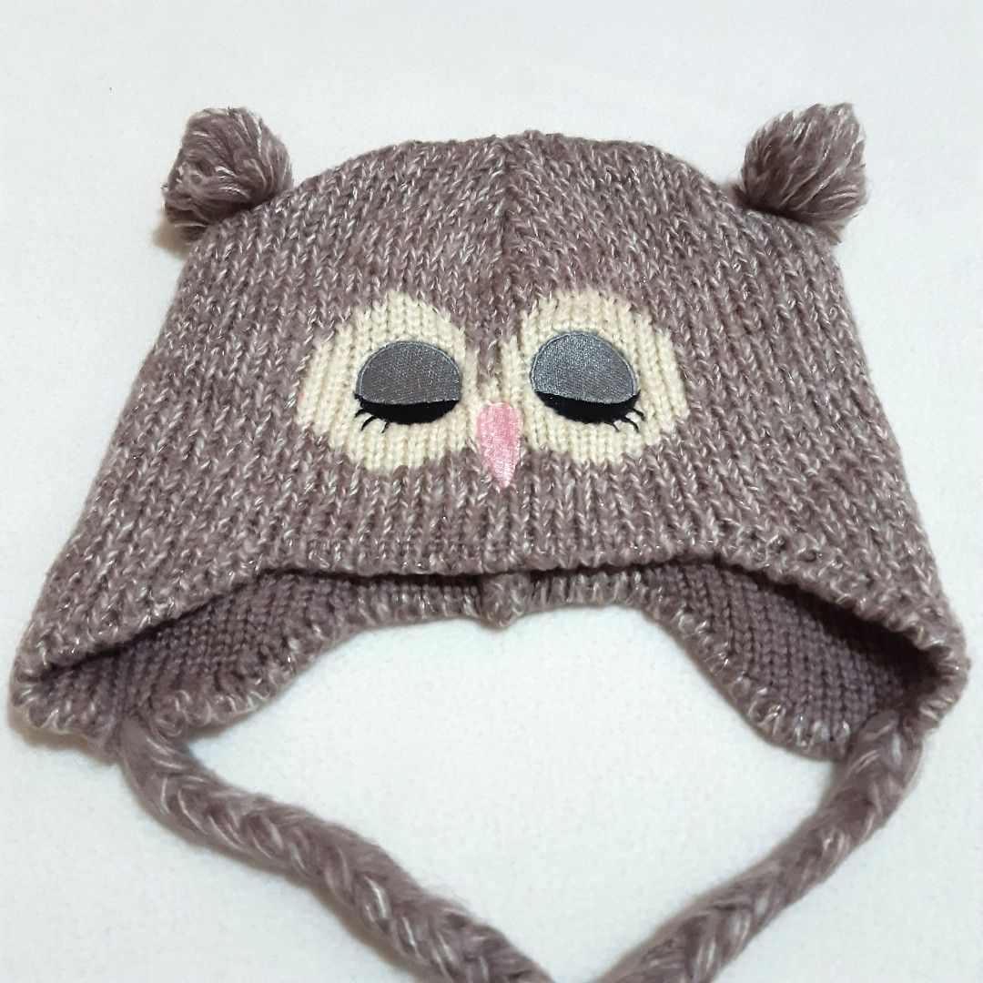 Funky Fish Owl Knitted Beanie Hat with Earflaps (Category: Hats & Beanies) located in Tuguegarao City. Submitted by thriftedtreasures101.1 (Listing ID 1466645526, Image 3). Description: Playful and quirky style beanie hat. It features a knitted eye patches with close eyelids, a tiny pink triangle beak, small ear-like tufts, braided earflap cords and a subtle metallic or glitter thread woven into the knit. Slightly used, in good condition. Size Me