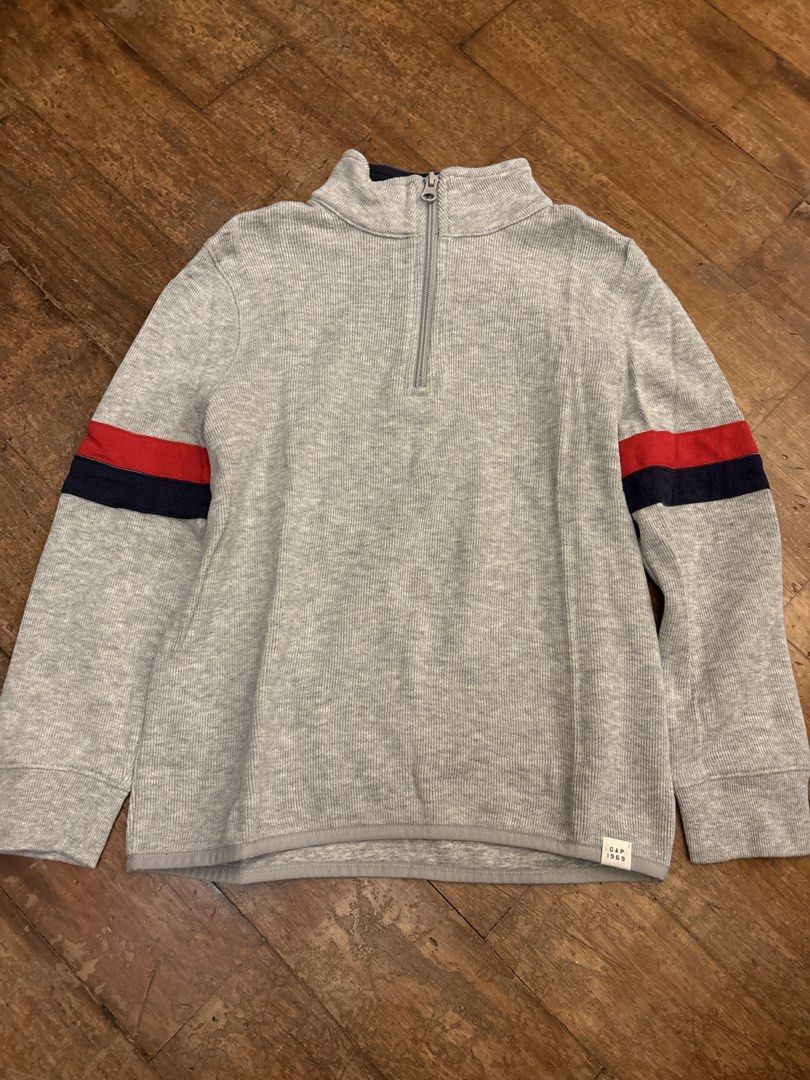 Gap Kids Grey 1/4 Zip Sweater Size S (Category: Babies & Kids Fashion) located in Makati City. Submitted by shoplecloset (Listing ID 1466683444, Image 1). Description: - Brand/Model: Gap Kids Grey Quarter-Zip Sweater - Size: S - Material: Ribbed knit - Design Details: Red and navy blue stripes on both sleeves, high collar with zipper closure, and small Gap 1969 tag near bottom hem - Origin: Made in Vietnam - Condition: Clean and ready to wear - f