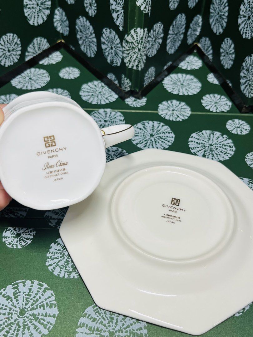 Givenchy Bone China Cup and Saucer Set (Category: Coffee & Tea Tableware) located in Malabon City. Submitted by mgsurplus (Listing ID 1466565052, Image 2). Description: - Brand: Givenchy (Made in Japan by Yamaka International) - Material: Premium white bone china porcelain - Design: Elegant blue geometric border with luxurious gold trim and unique octagonal saucer - Details: Features the iconic Givenchy logo on the side of the cup and the bottom 
