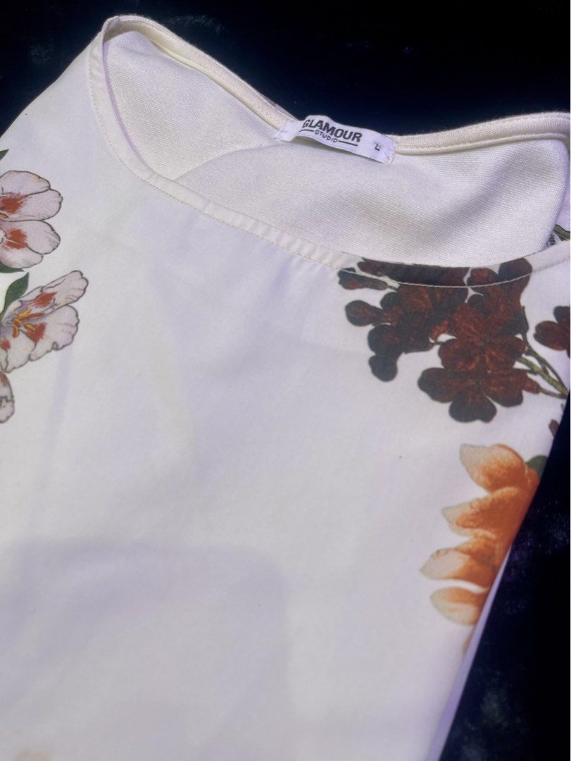 Floral Print Flutter Sleeve Blouse (Category: Blouses) located in Quezon City. Submitted by onesourceph (Listing ID 1466769264, Image 2). Description: - Brand: Glamour Studio - Size: M-L - Design: White blouse with striking red and white floral print - Details: Round neckline and trendy layered flutter sleeves - Fit: Lightweight and relaxed for all-day comfort - Styling: Easy to match with casual trousers or skirts.
