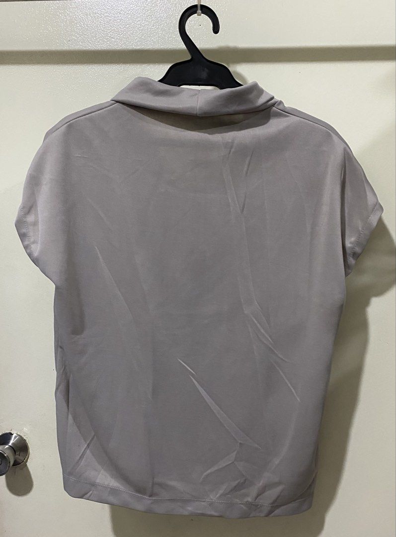 Grey cowl neck short sleeve blouse top (Category: Blouses) located in Manila. Submitted by divinemercy_29 (Listing ID 1466635182, Image 2). Description: - Color: Grey - Neckline: Relaxed cowl neck - Sleeves: Cap sleeves - Hem: Straight hem - Fabric: Smooth with slight stretch - Fit: Comfortable and versatile for casual wear or work.