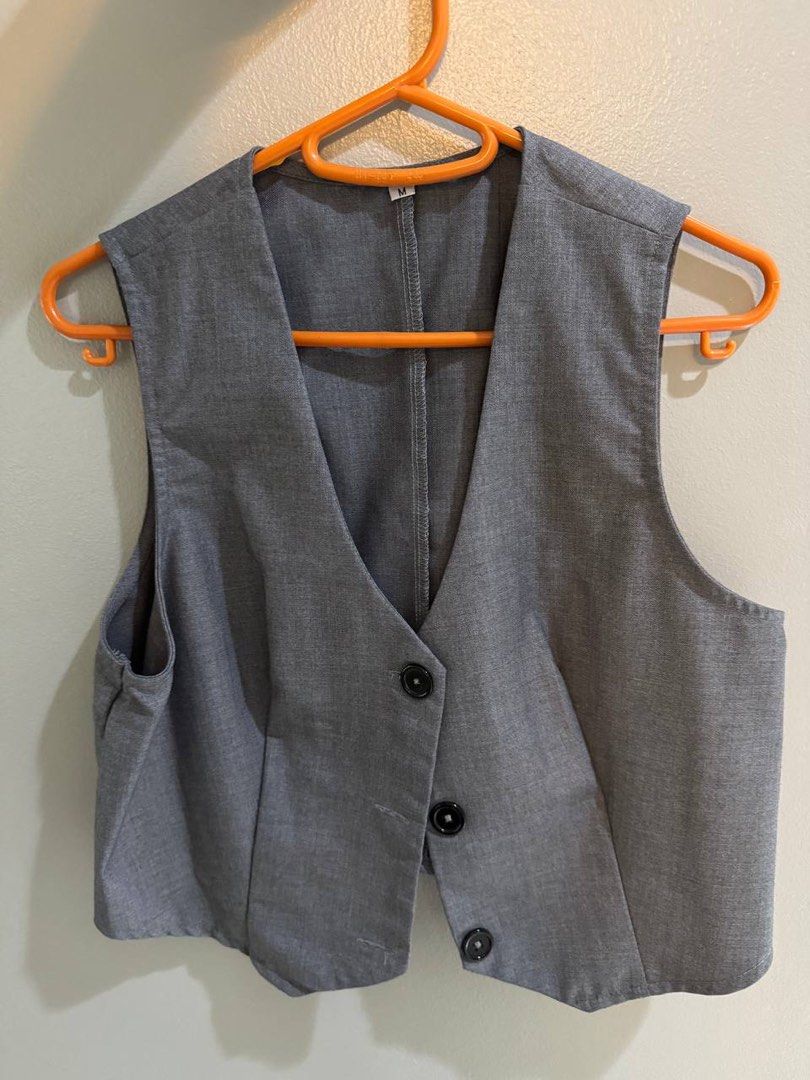 Grey cropped waistcoat vest size M (Category: Sleeveless) located in Taguig. Submitted by anxmz (Listing ID 1466676639, Image 1). Description: - Size: Medium - Color: Grey - Design: V-neck with 3 black front buttons and cropped length - Details: Neat stitching along the back seam, unbranded basic piece - Styling: Great layering item for both casual and smart outfits.