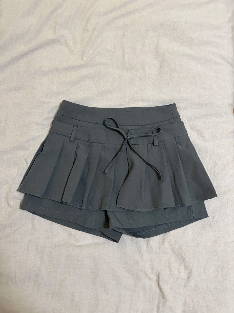 Grey Pleated Skort with Ribbon (Category: Skirts) located in Makati City. Submitted by sbllia (Listing ID 1466609694, Image 1). Description: - Color: Dark grey - Size: Small - L: 35cm, W: 64cm - High-waisted pleated skirt with pleats - Built-in shorts for comfort and coverage - Details: Decorative belt loops and front drawstring tie.