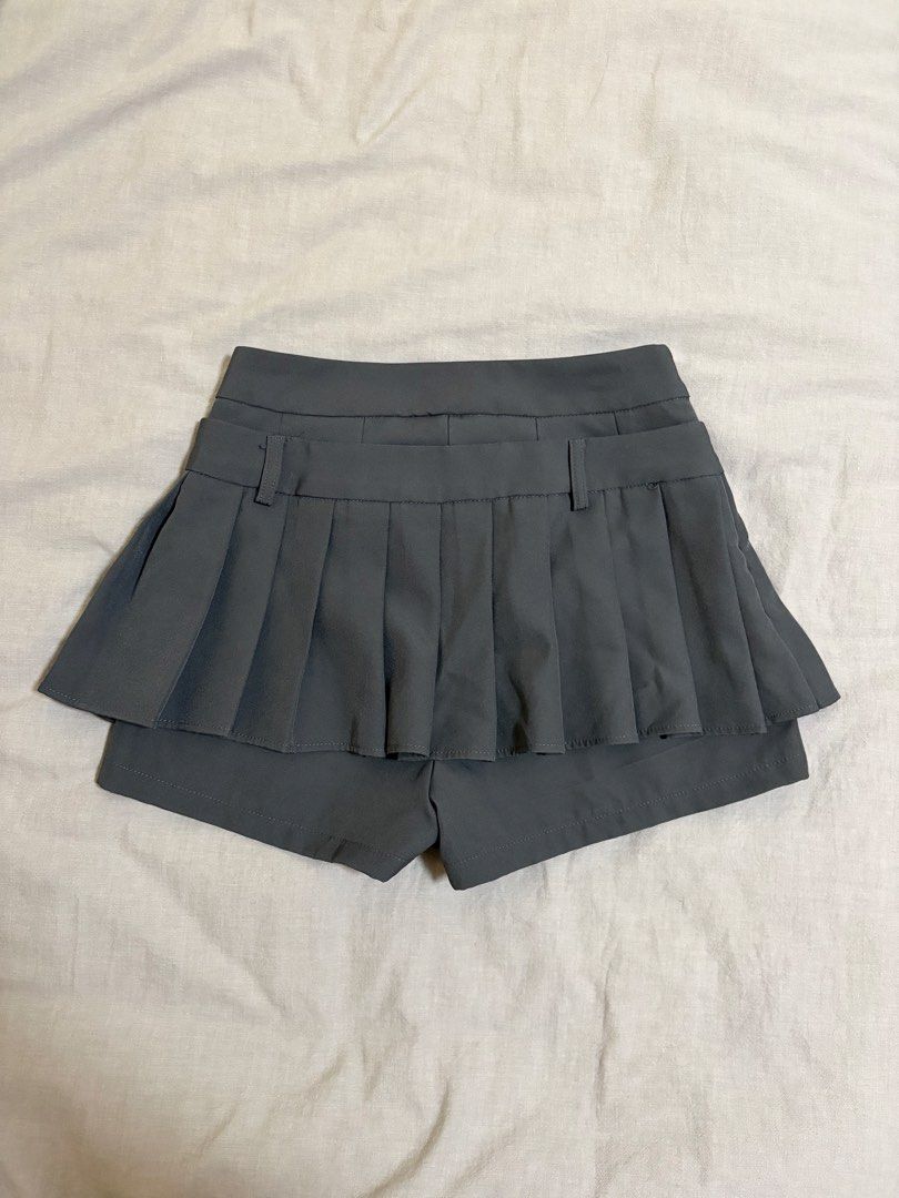 Grey Pleated Skort with Ribbon (Category: Skirts) located in Makati City. Submitted by sbllia (Listing ID 1466609694, Image 2). Description: - Color: Dark grey - Size: Small - L: 35cm, W: 64cm - High-waisted pleated skirt with pleats - Built-in shorts for comfort and coverage - Details: Decorative belt loops and front drawstring tie.