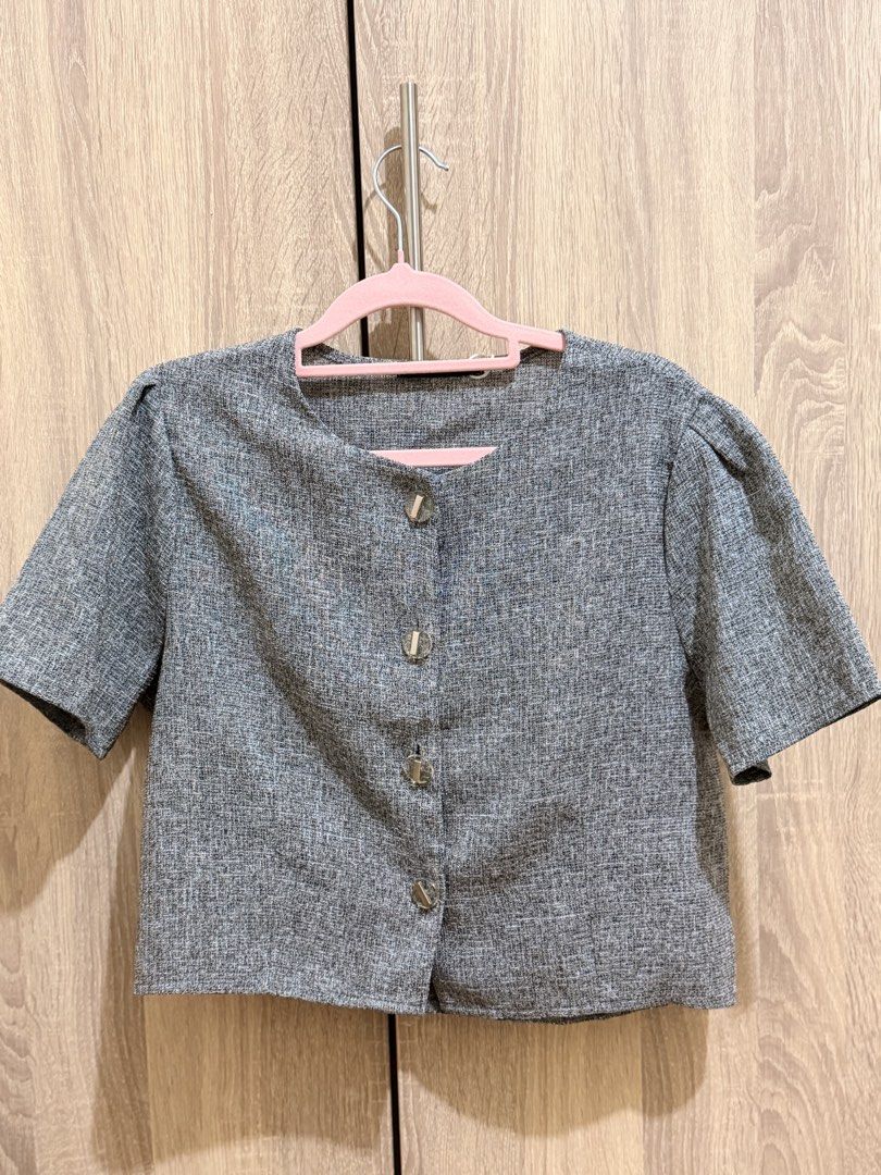 Grey Short Sleeve Crop Top Blouse with Buttons (Category: Blouses) located in Manila. Submitted by anj_1414 (Listing ID 1466768286, Image 1). Description: - Color: Grey - Fabric: Textured material, clean and ready to wear - Design: Round neckline with 4 silver front buttons, chic puffed shoulders - Fit: Cropped length, perfect for high-waisted jeans or skirts.