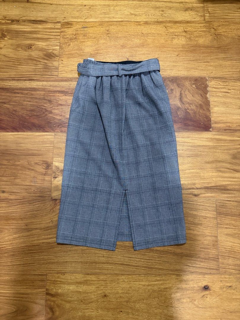 GU Gray Plaid Midi Skirt Size S (Category: Skirts) located in Manila. Submitted by lifewithmazel (Listing ID 1466583631, Image 2). Description: - Brand: GU - Size: S (tag attached) - Pattern: Gray plaid - Style: High waist with matching fabric front-tie belt - Comfort: Back slit at the bottom hem for easy movement - Lining: Fully lined with smooth black fabric.