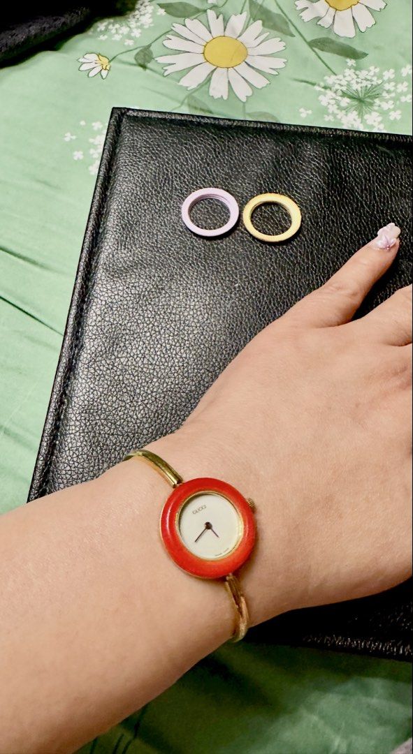 Gucci Bangle Watch with Interchangeable Bezels (Category: Women's Watches) located in Paranaque City. Submitted by love1927 (Listing ID 1466720216, Image 1). Description: - up for grabs is my Mom’s vintage Gucci she bought it in year 1990’s - Design: Gold-tone bangle strap with classic round white dial - Included Bezels: 3 interchangeable bezels (Red attached + Purple and Yellow extras) - Details: Gucci branding stamped on clasp - Condition: Good