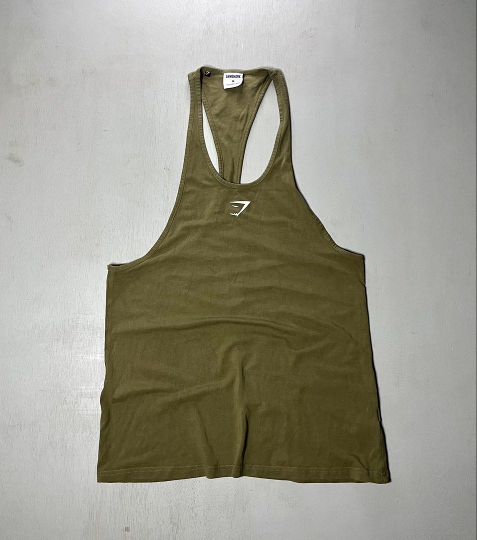 Gymshark Olive Green Stringer Tank Top Size M (Category: Activewear) located in Catbalogan. Submitted by yellfindss (Listing ID 1466753119, Image 1). Description: - Brand: Gymshark 18/29 - Item: Stringer Tank Top - Color: Olive Green - Size: Medium - Material: 95% Cotton, 5% Elastane - Style Code: GMSR3250-OGN - Features: Classic racerback, white chest logo - Condition: Clean fabric with clear collar tag branding.