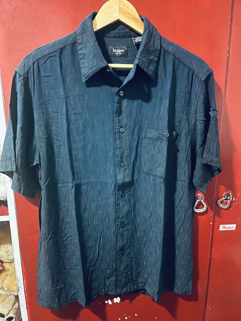 Haggar Men’s Polo (Category: Formal Shirts) located in Quezon City. Submitted by wacpon_061972 (Listing ID 1466683593, Image 2). Description: The image shows a dark blue short-sleeve button-up shirt by Haggar featuring a subtle textured or patterned weave and a single chest pocket..