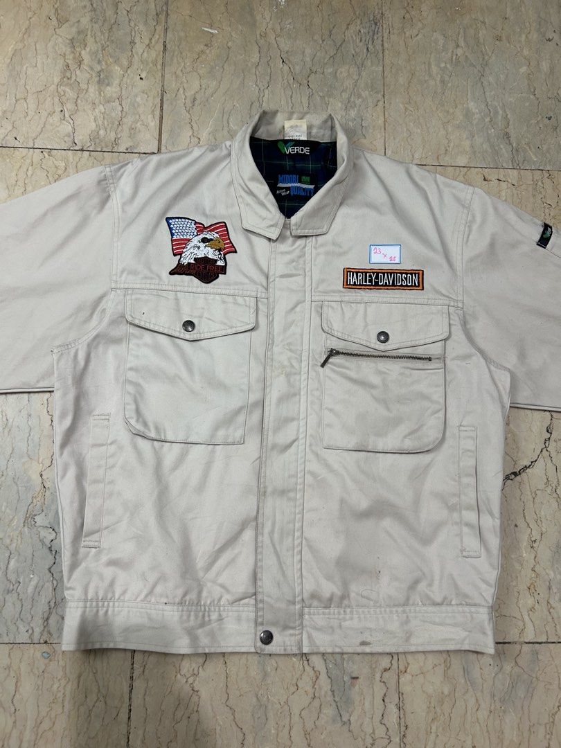 Harley-Davidson Beige Work Jacket with Eagle Patch (Category: Coats, Jackets and Outerwear) located in Mandaluyong City. Submitted by 0lg2026 (Listing ID 1466751378, Image 3). Description: - Color: Classic beige - Material: Sturdy, durable cotton - Branding: Harley-Davidson chest lettering patch - Detail: American flag eagle patch on the right pocket - Storage: Multiple front snap-button pockets and a secure zippered compartment - Design: Classic