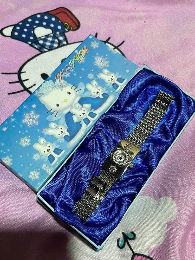 Hello Kitty Rhinestone Analog Watch with Gift Box (Category: Women's Watches) located in Manila. Submitted by janetecson05 (Listing ID 1466586761, Image 1). Description: - Authentic Kitty themed analog watch in a sleek silver tone - Sparkling rhinestone bezel and cute Kitty watch face graphic - Charming decorative flower accents on the rectangular case - Adjustable metal mesh strap with a secure clasp closure - Includes original collectible blue 