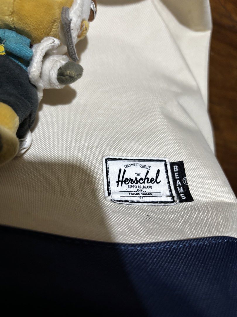 Herschel Supply Co. x Beams Backpack (Category: Backpacks) located in Malaybalay. Submitted by ziggyy. (Listing ID 1466693935, Image 2). Description: - Authentic Herschel Supply Co. x Beams collaboration backpack - Stylish white canvas body with a contrast navy blue base and top flap - Secure drawstring closure with snap button fasteners - Vibrant orange and white striped inner lining with an interior zip pocket - Comfortable adjustable padded sh