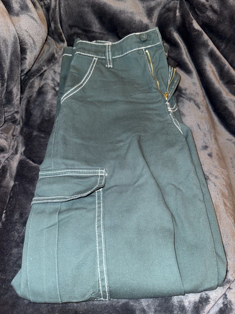 H&M Divided Green Cargo Pants Size US 4 (Category: Jeans) located in Angeles City. Submitted by kkucart (Listing ID 1466691369, Image 1). Description: - Brand: H&M Divided - Size: EUR 36 / US 4 / CA 4 / MX 4 - Color: Dark forest green with contrast white stitching - Fit: Mid-rise with a relaxed straight leg cut - Details: Zip fly with button closure and functional side utility pockets - Condition: Worn 1-2 times, still looks great - Note: Refer t