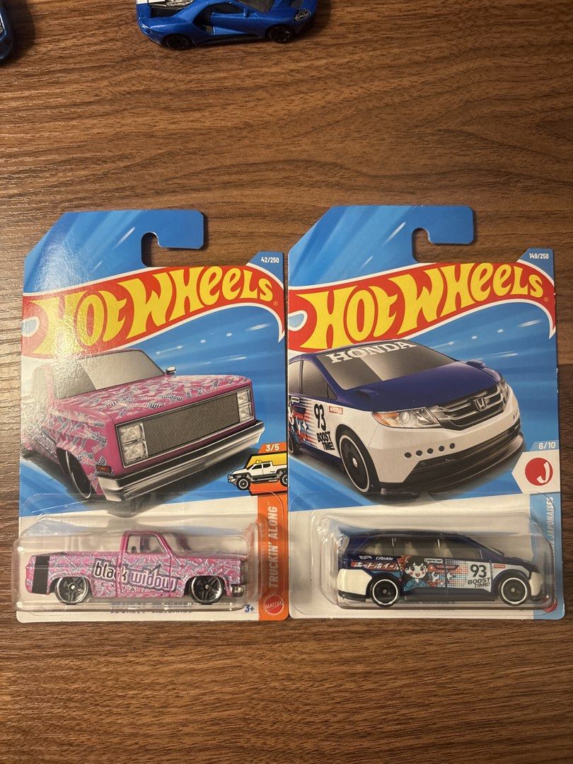 Hot Wheels 2026 (Category: Vehicle & Diecast Models) located in General Trias. Submitted by james1815 (Listing ID 1466667108, Image 1). Description: PHP150 each Bawal sa maselan - Hot Wheels mainlines - 1st item: Pink Truckin Along pickup truck with black widow livery (42/250) - 2nd item: Blue and white Honda Odyssey minivan with number 93 and anime graphics (149/250) - Condition: Flat cards with hanging tabs intact - Packaging: Clear and undamag