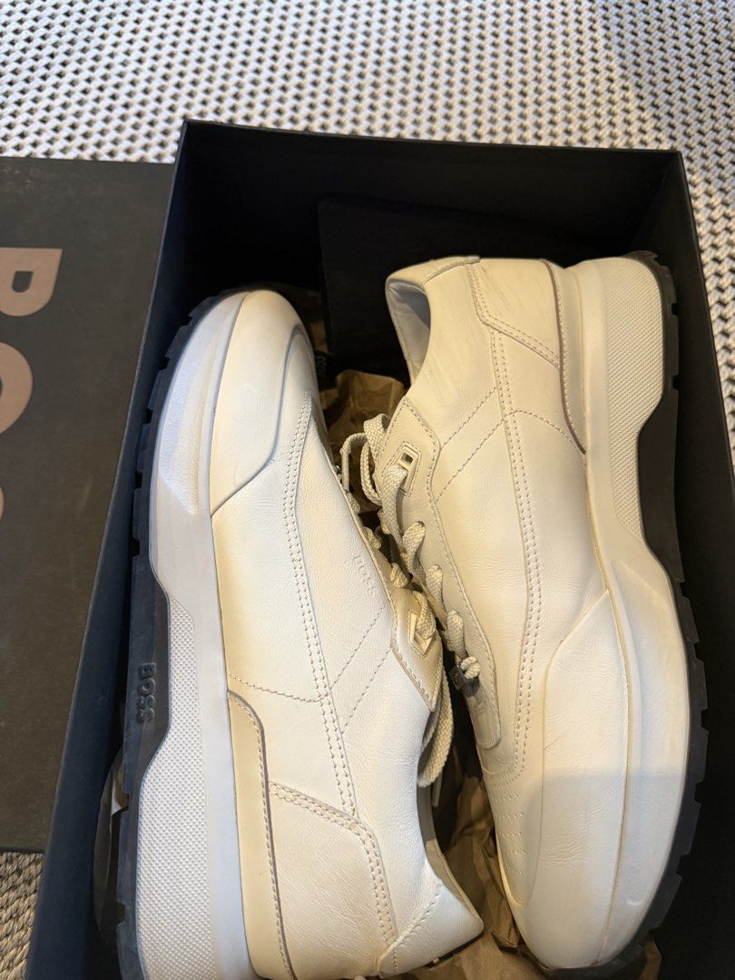 HUGO BOSS Cream White Leather Sneakers (Category: Sneakers) located in Manila. Submitted by shan.rubio (Listing ID 1466644913, Image 2). Description: - Brand: BOSS - Color: Classic Cream White - Material: Premium Leather with chunky rubber sole - Design details: Subtle perforated toe, metal branding plaque on laces, and embossed logo on the side - Inclusion: Original black presentation box - Condition: Minor creasing on the side leather from prev