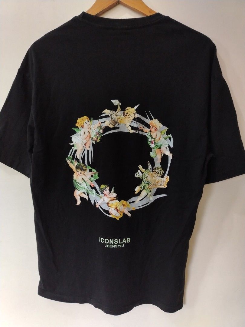 Iconslab Black Graphic Tee Medium (Category: Tshirts & Polo Shirts ) located in Manila. Submitted by zyclothing03 (Listing ID 1466630385, Image 2). Description: - Brand/Model: Iconslab t-shirt - Size: Medium - Color/Material: Solid black cotton - Design Front: Green text with a cherub graphic and tape design overlay - Design Back: Circular graphic made of multiple cherub illustrations with 'Iconslab Jeensyiu' text - Fit/Cut: Short sleeves with a 