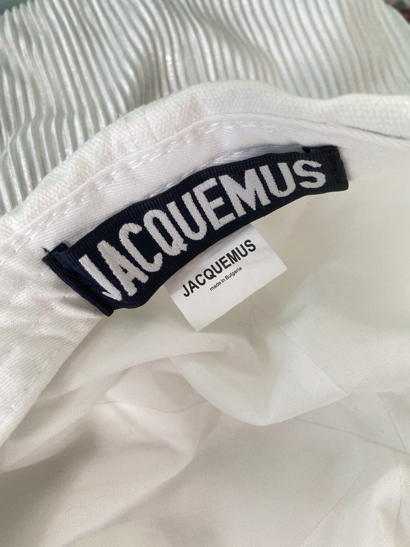 Jacquemus White Baseball Cap with Frayed Edge (Category: Caps & Hats) located in Tabaco. Submitted by camila_p (Listing ID 1466613863, Image 3). Description: - Brand: Jacquemus - Color: Clean White - Material: Canvas - Features: Metal front logo lettering, trendy frayed brim edge - Hardware: Adjustable metal buckle strap with silver-tipped hanging drawstrings - Origin: Made in Bulgaria - Condition: Excellent.