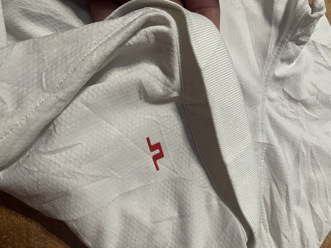 j.lindeberg Regular Fit White Polo Shirt (Category: Tshirts & Polo Shirts ) located in Panabo. Submitted by sales.mad (Listing ID 1466737569, Image 3). Description: - Brand: J.Lindeberg - Style: Regular fit polo shirt - Color: Clean white with a small red embroidered chest logo - Features: Classic collar, button placket, and breathable textured fabric - Size: Small (tag and interior neck labels intact) -21x28 dimension - Condition: Excellent, rea