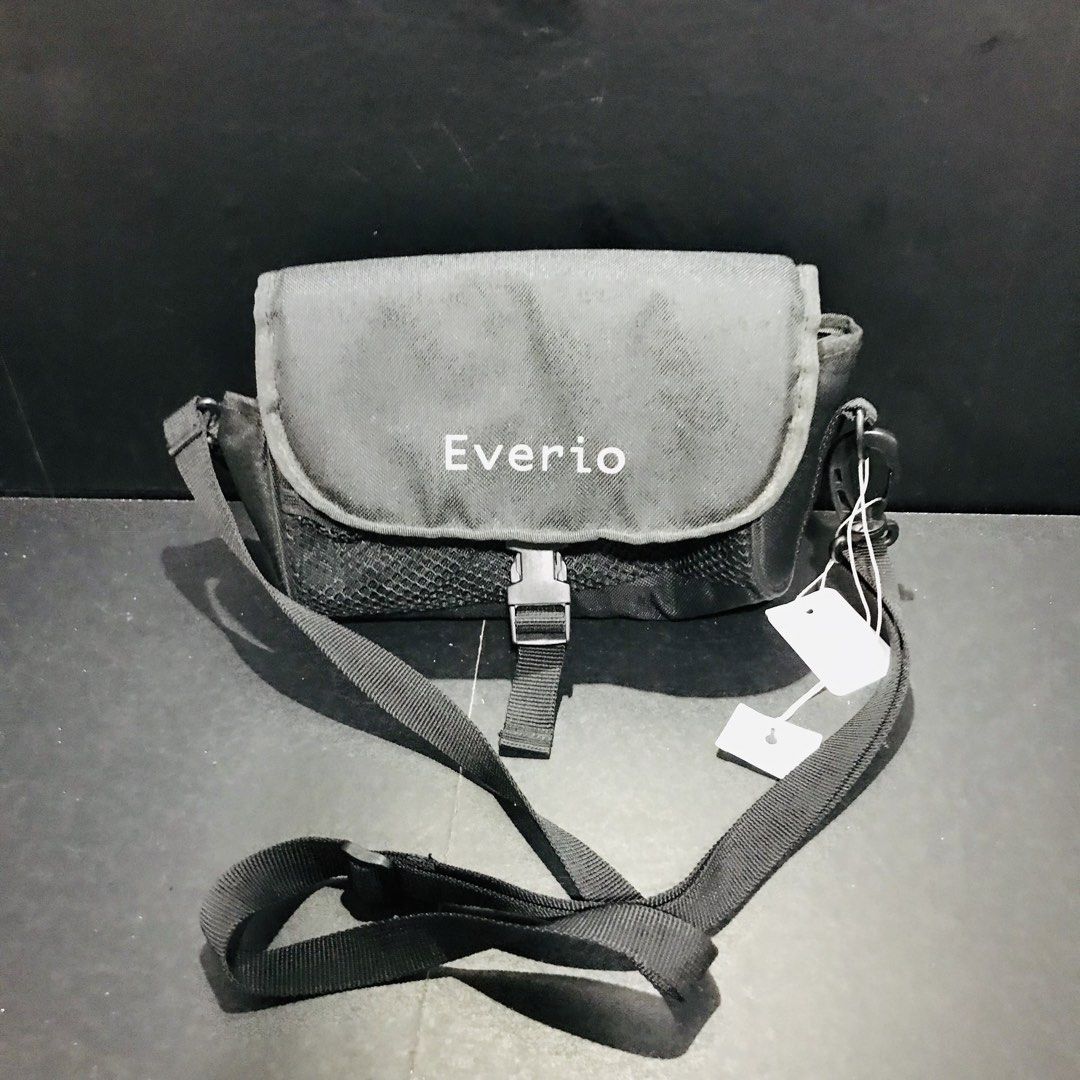 JVC Everio black camera shoulder bag strap mesh pockets (Category: Camera Bags & Carriers) located in Baao. Submitted by all.things.japan (Listing ID 1466705379, Image 2). Description: 4.0 x 4.0 x 8.5 inches - Brand new black canvas camera shoulder bag with white tags attached - Features Everio logo on the front flap - Adjustable black strap and secure plastic buckle closure - Convenient side mesh pockets for extra storage - Padded interior with 
