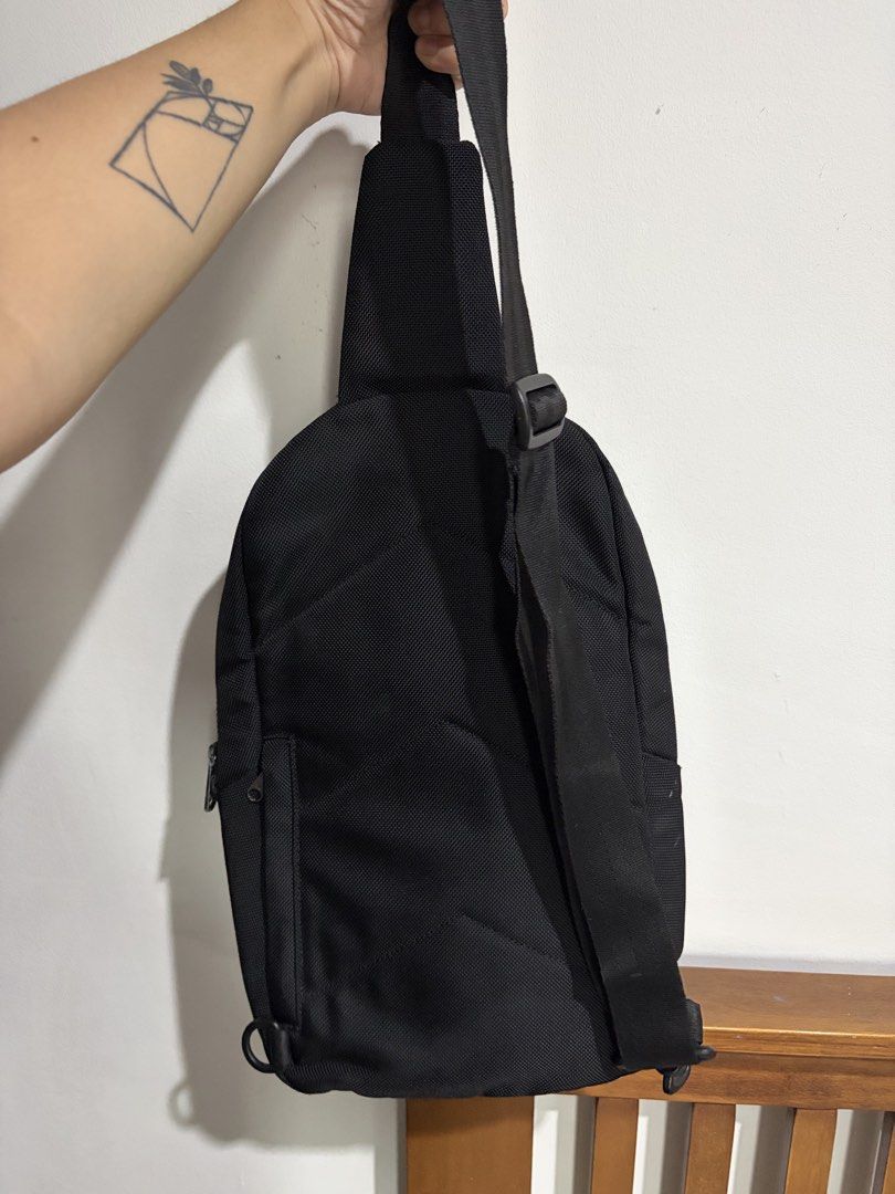 Kangol Black Sling Bag Crossbody Backpack (Category: Sling Bags) located in Marikina City. Submitted by kim_sanaaa (Listing ID 1466772150, Image 2). Description: - Authentic Kangol sling bag in classic black - Vibrant blue interior lining - Multiple exterior and interior zippered pockets for easy organization - Adjustable single shoulder strap for comfort - Premium branded zippers and iconic embroidered kangaroo logo Issues: Lost 1 main zipper (s