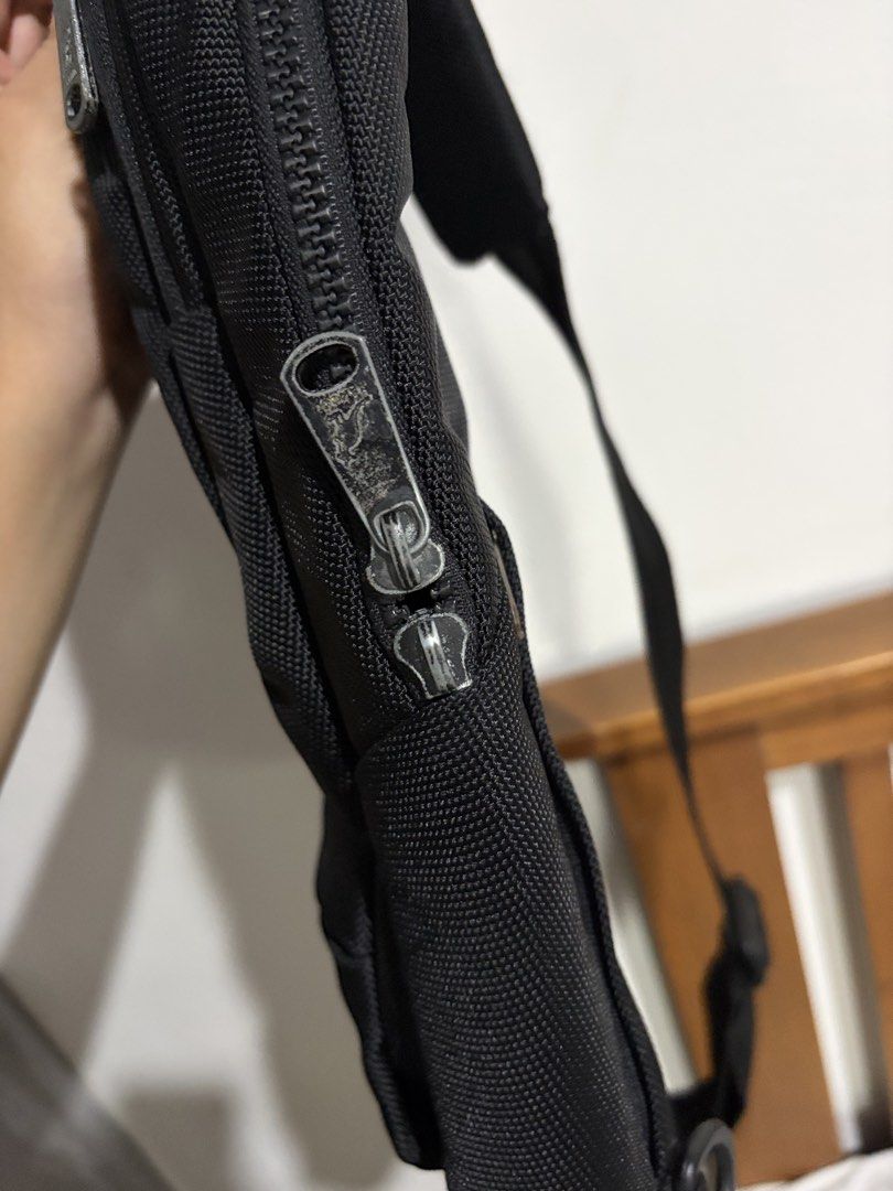 Kangol Black Sling Bag Crossbody Backpack (Category: Sling Bags) located in Marikina City. Submitted by kim_sanaaa (Listing ID 1466772150, Image 3). Description: - Authentic Kangol sling bag in classic black - Vibrant blue interior lining - Multiple exterior and interior zippered pockets for easy organization - Adjustable single shoulder strap for comfort - Premium branded zippers and iconic embroidered kangaroo logo Issues: Lost 1 main zipper (s