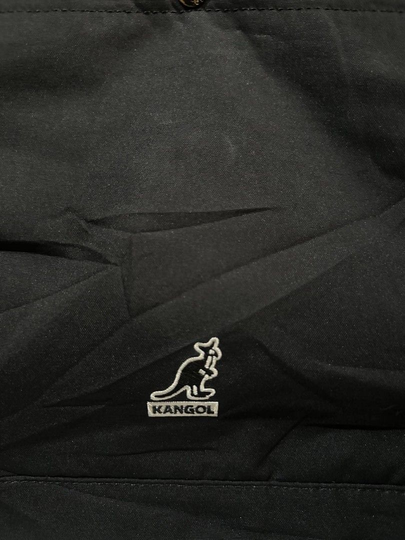 Kangol Black Tote Bag with Pockets (Category: Tote Bags) located in Pasacao. Submitted by kishhuschka (Listing ID 1466651541, Image 3). Description: - Kangol black canvas tote bag - Large main compartment fits books and a laptop - Front pocket with secure snap button closure - Convenient side pockets for quick access - Durable and sturdy black shoulder straps (Adjustable) - Classic embroidered Kangol logo on the front - 'Born British' side tag de