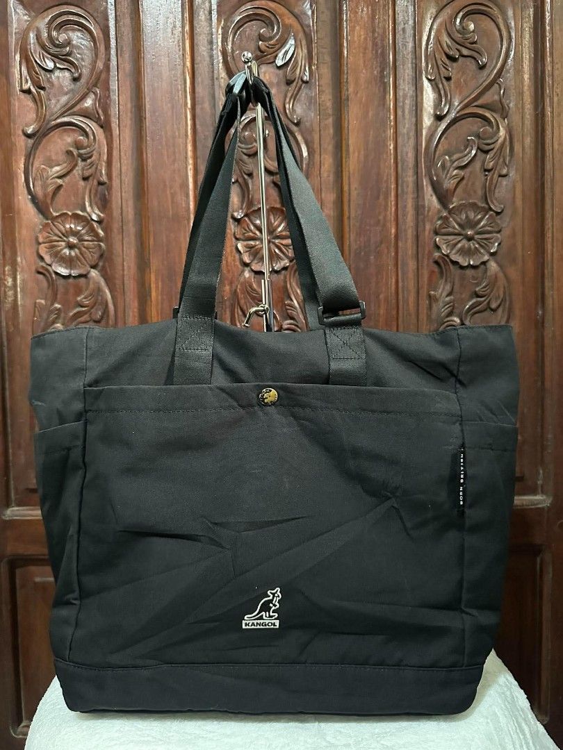 Kangol Black Tote Bag with Pockets (Category: Tote Bags) located in Pasacao. Submitted by kishhuschka (Listing ID 1466651541, Image 1). Description: - Kangol black canvas tote bag - Large main compartment fits books and a laptop - Front pocket with secure snap button closure - Convenient side pockets for quick access - Durable and sturdy black shoulder straps (Adjustable) - Classic embroidered Kangol logo on the front - 'Born British' side tag de
