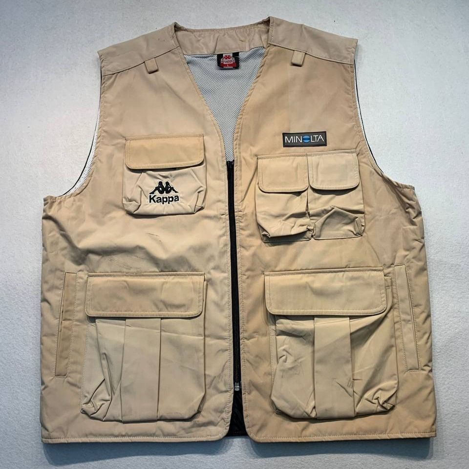 Kappa x Minolta Beige Utility Cargo Vest (Category: Vests) located in Mandaluyong City. Submitted by theroom501 (Listing ID 1466687068, Image 1). Description: Kappa x Minolta Beige Utility Cargo Vest Style Code: Size on Tag: Large Color: Cream Condition: Good pre-owned condition with a heavily distressed vintage look. Flaws/Issues: Discoloration and Crack print dust stain need wash. Flat Lay Measurements: Pit to Pit: 23 inches Length: 25.5 inches
