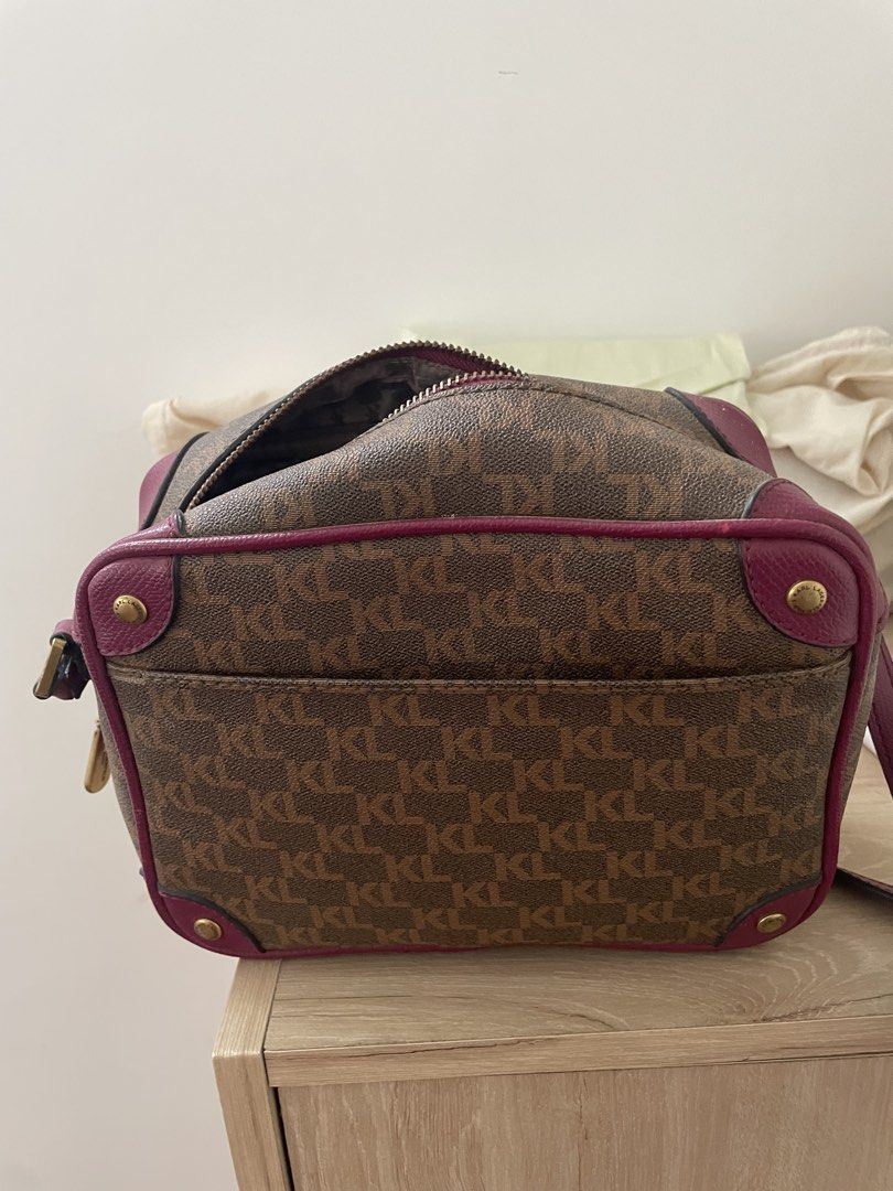 Karl Lagerfeld Monogram Crossbody Handbag (Category: Cross-body Bags) located in Cordova. Submitted by fiercedragon.47e450 (Listing ID 1466605014, Image 2). Description: - Brand: Karl Lagerfeld - Design: Classic brown monogram print with contrasting magenta pink trim and leather details - Hardware: Premium gold-toned hardware (zipper pull and adjustable shoulder strap buckle) - Interior: Patterned grey fabric lining with an internal zipped pocket