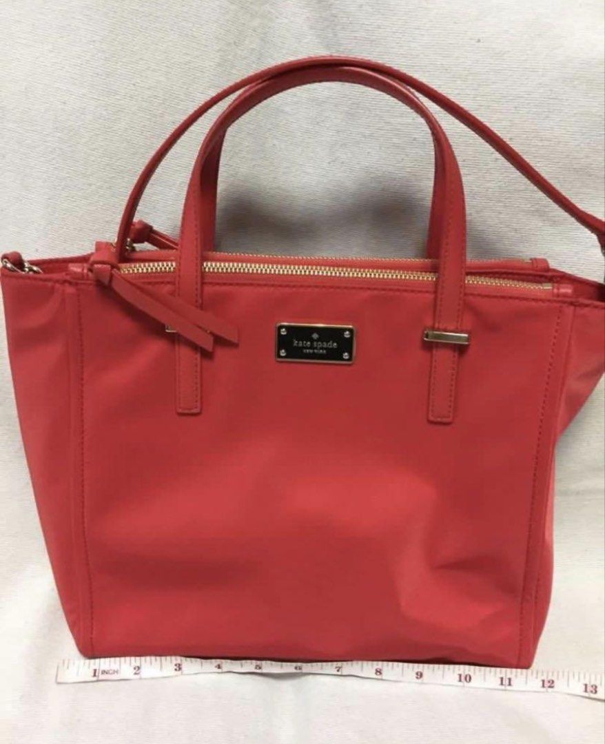 Kate Spade Red Nylon Tote Bag (Category: Tote Bags) located in Quezon City. Submitted by tinamartinez (Listing ID 1466604375, Image 1). Description: - Brand: Kate Spade - Color: Bright red with gold-tone hardware - Material: Durable nylon - Closure: Top zip closure - Handles: Double top handles plus an extra strap included - Interior: Signature logo fabric lining with a zipper pocket - Dimensions: Approximately 11 inches across the base and 8.5 i