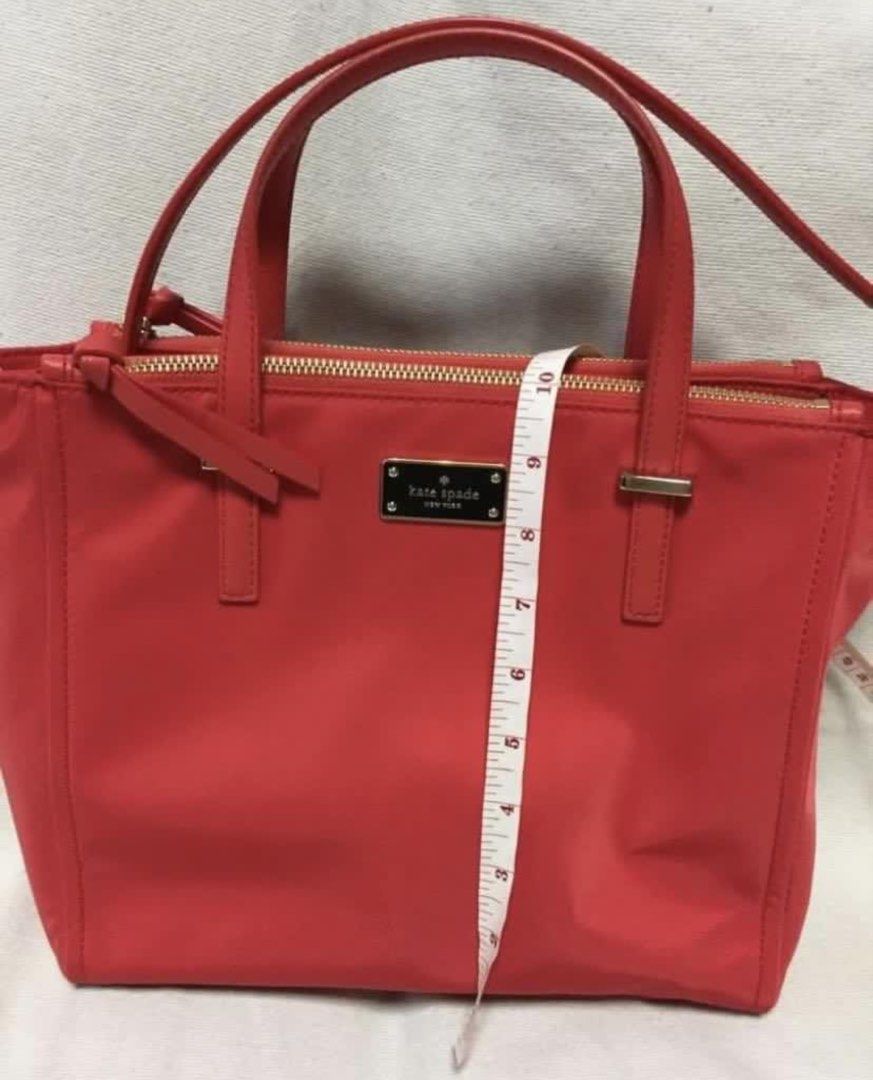 Kate Spade Red Nylon Tote Bag (Category: Tote Bags) located in Quezon City. Submitted by tinamartinez (Listing ID 1466604375, Image 2). Description: - Brand: Kate Spade - Color: Bright red with gold-tone hardware - Material: Durable nylon - Closure: Top zip closure - Handles: Double top handles plus an extra strap included - Interior: Signature logo fabric lining with a zipper pocket - Dimensions: Approximately 11 inches across the base and 8.5 i