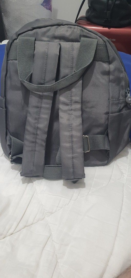 Kipling Grey Backpack with Front Pockets (Category: Backpacks) located in Paranaque City. Submitted by personal_preloved40 (Listing ID 1466656411, Image 3). Description: - Brand: Kipling - Color: Dark grey with grey and white striped interior lining - Condition: Brand new with original tags, kept in protective plastic - Features: Dual zippered front pockets, top grab handle, and adjustable back straps - Interior: Includes convenient slip compartm