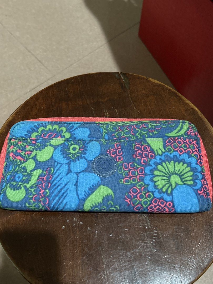 Kipling Long Zip Around Wallet Blue Floral (Category: Wallets & Card holders) located in Alitagtag. Submitted by patrickvillanueva (Listing ID 1466630273, Image 1). Description: - Brand: Kipling - Design: Blue with a colourful floral pattern and bright pink zip trim - Features: Multiple card slots, cash compartments, and a clear ID window - Condition: Interior fabric has some staining and marks from use; zip closure works smoothly - Perfect size 