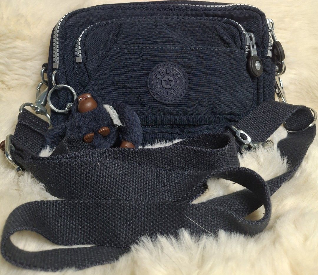 Kipling Merryl sling/belt bag (Category: Cross-body Bags) located in Rizal. Submitted by emskititay (Listing ID 1466692257, Image 1). Description: Kipling Merryl Sling/Belt bag ₱1200 ●2 in 1 sling or belt bag ●with monkey ●10/10 color condition ●Blue tonal ●H 13 cm x L 19 cm x W 8 cm ●Replaced side hook hardware and cracking on belt bag strap leather part only Location: Taytay Rizal 💼Rfs Decluttering my kipling collections.