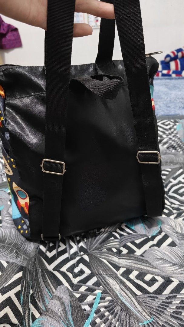 Kittly Space Print Kids Backpack with Solar System Design (Category: Backpacks) located in Manila. Submitted by phcarousince2016 (Listing ID 1466651338, Image 3). Description: - Brand: Kittly - Design: Fun outer space pattern with cartoon planets (Jupiter, Mars, Earth, Saturn), sun, and rockets on a dark background - Closure: Top zipper closure - Comfort: Adjustable black shoulder straps and a convenient grab handle - Storage: Handy exterior side