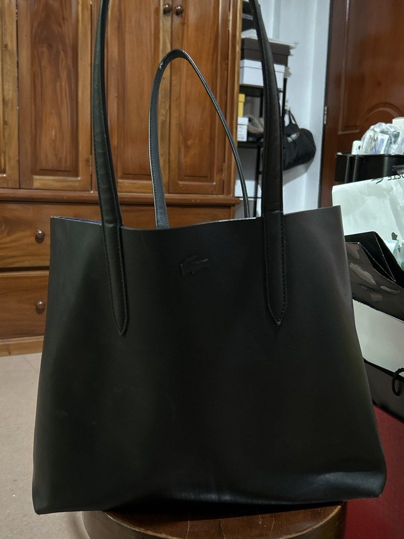 Lacoste Black Pure Leather Tote Bag (Category: Tote Bags) located in Alitagtag. Submitted by patrickvillanueva (Listing ID 1466619279, Image 1). Description: I bought this for ₱18,000+ at Lacoste Solaire. - Brand: Lacoste - Color: Black exterior with a contrasting metallic blue interior - Material: Genuine leather - Design: Minimalist style with front embossed crocodile logo, dual shoulder straps, and open top - Condition: Good, with minor scuffs